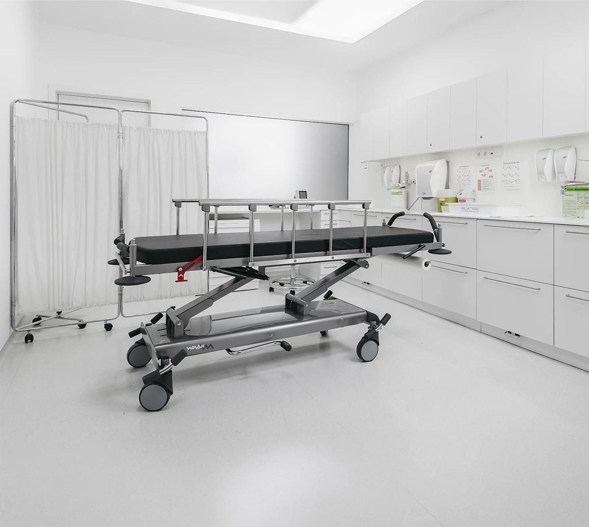 Stretcher with safety rails in a bright clinical treatment room