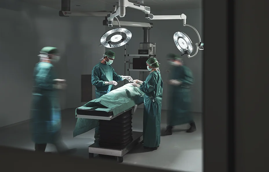 Operationsteam arbeitet während eines Eingriffs am Patienten auf dem OP-Tisch.