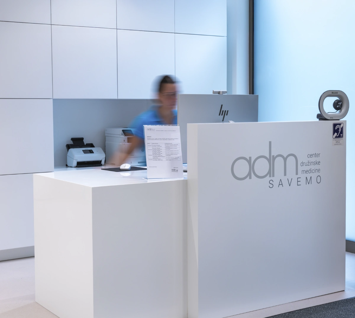 nurse at reception desk works on comuter